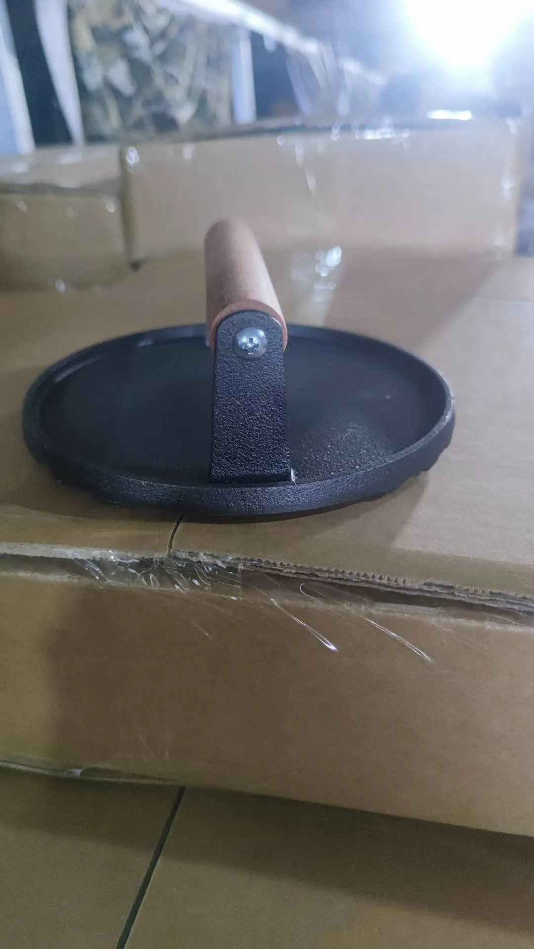 Side view of round cast iron grill press